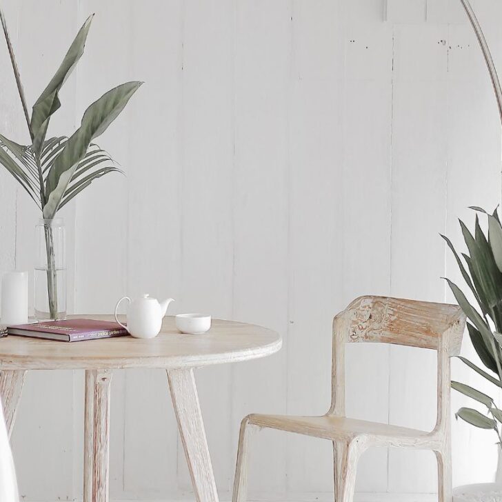 bright space with light tan reading table and plant near curtained window