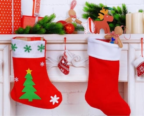 white fireplace with mantel, and two Christmas stockings for men hanging