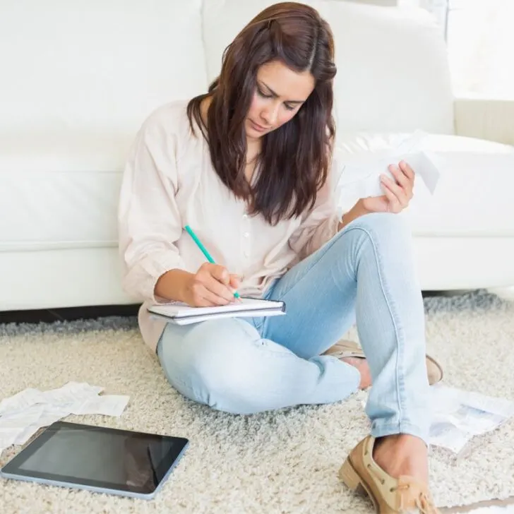 young woman on floor working on finances