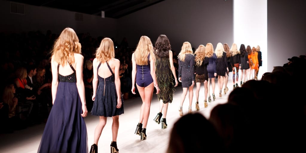 line of runway models, all in navy blue clothing
