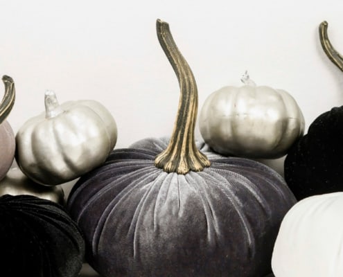 black, charcoal gray, and white pumpkins on a white background