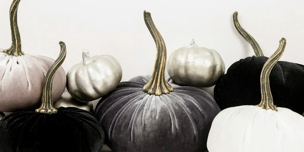 black, charcoal gray, and white pumpkins on a white background