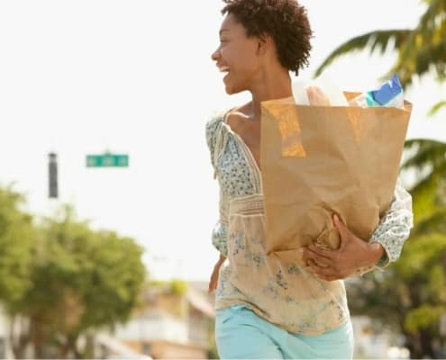 young woman with grocery bags from extreme couponing trip