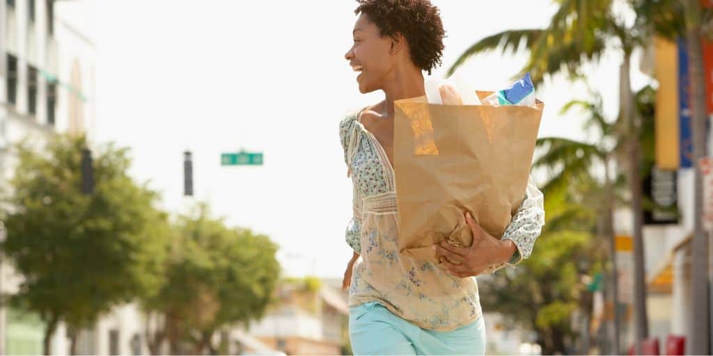 young woman with grocery bags from extreme couponing trip