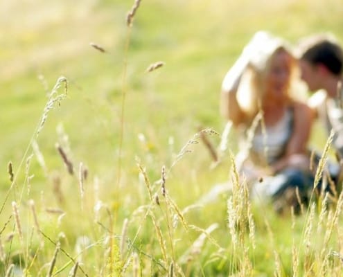 blurry shot of a couple in a beautiful meadow, talking