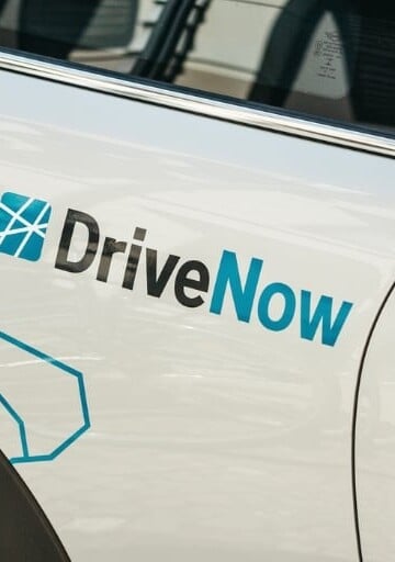 white car with car advertisement wrapping "Drive Now"