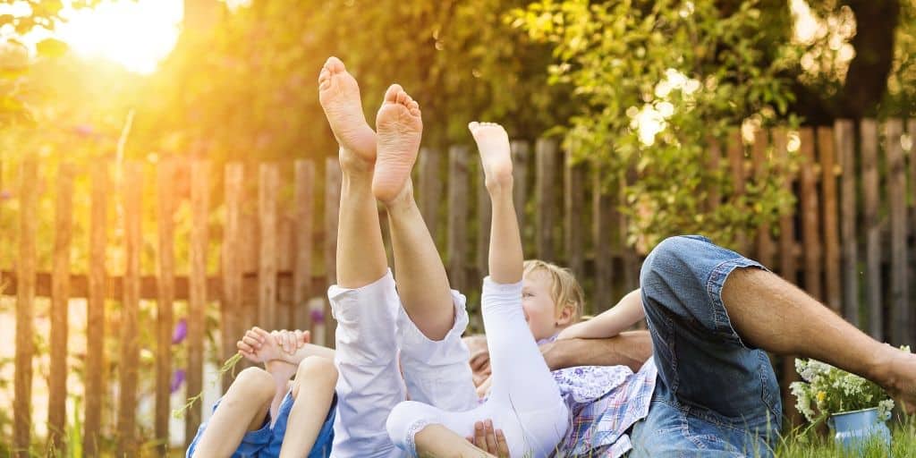 family playfully wrestling on the grass, sunny afternoon