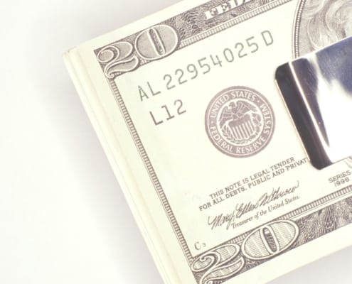 money clip with $20 bills on white background
