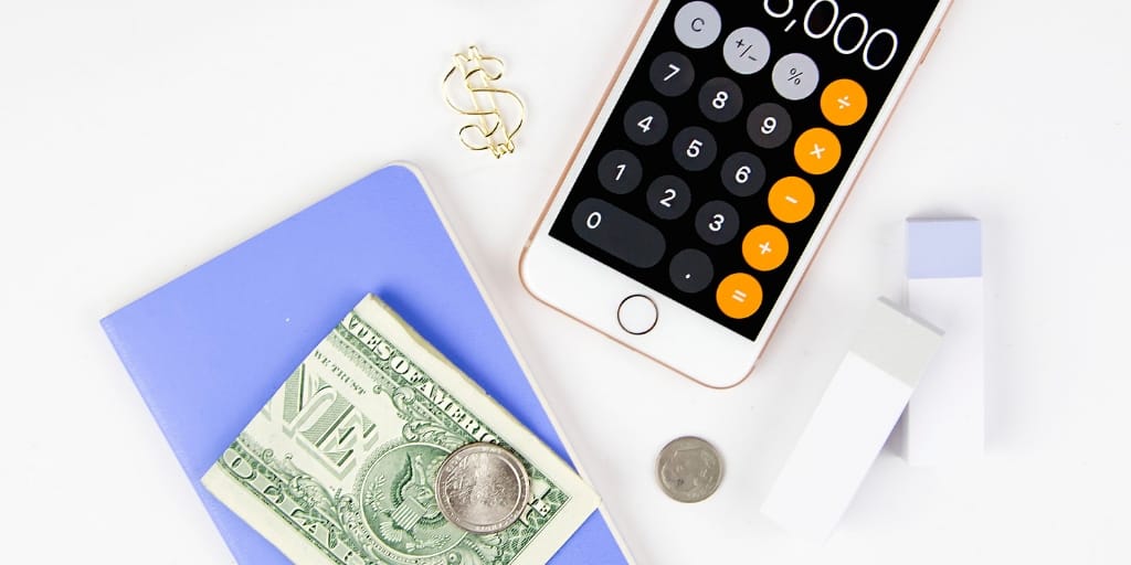 calculator and money sitting on a desk