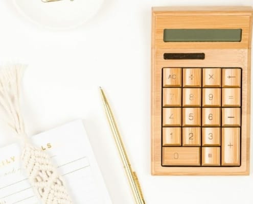 wooden calculator on white desk, flatlay