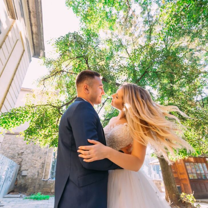 newlywed couple hugging each other outside