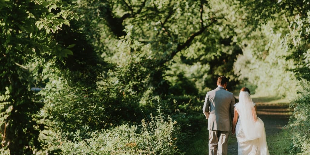 a bride and groom walking in forest, hoping to avoid financial marriage problems