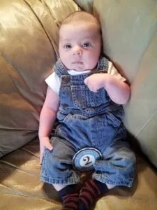 Conner 2 Months in jean overalls and white shirt