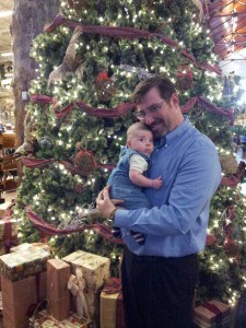 Conner and Dad in front of a large Christmas tree