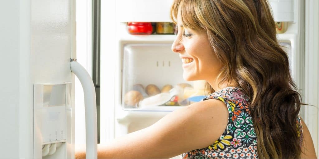 mother opening up freezer to pick healthy freezer meal