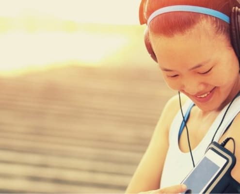 young asian woman looking down at her iphone about to exercise