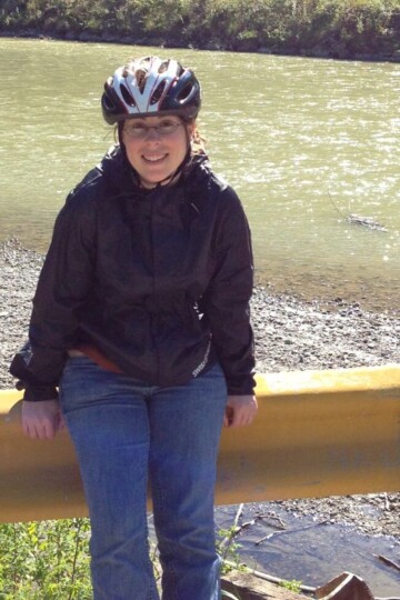 author in Alaska smiling with river in background