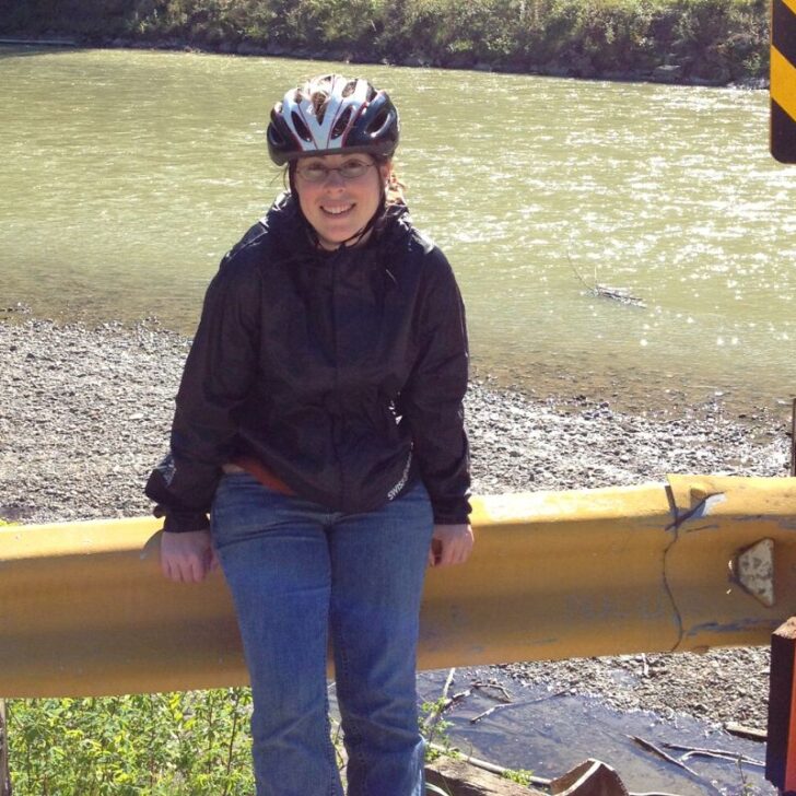 author in Alaska smiling with river in background