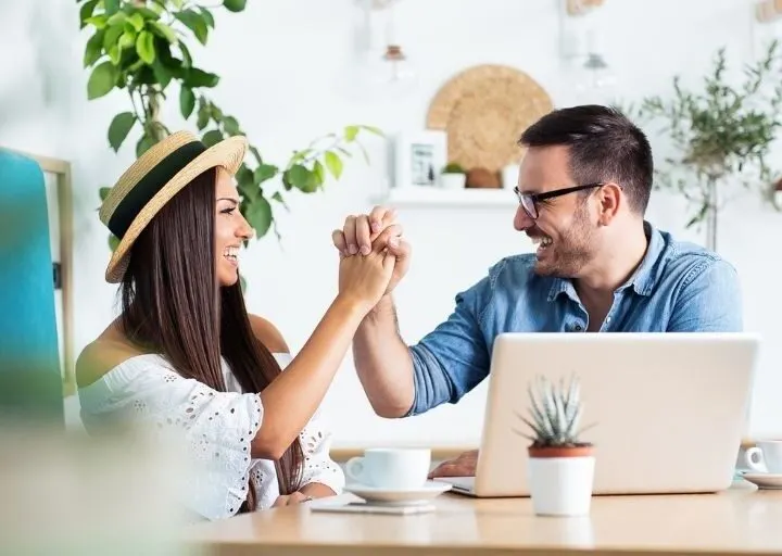 couple excitedly working together and congratulation each other on using the best way to pay off debt