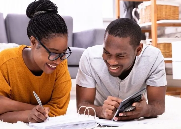 couple on floor, smiling, working on getting finances under control again