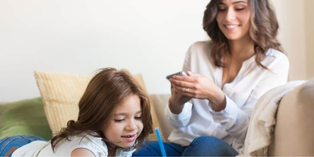 a mother managing money on the couch while child colors