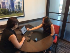 author with banker at PurePoint bank, looking at laptop screen