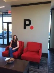 author sitting in red chair in PurePoint bank lobby