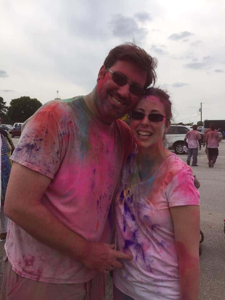Photo of my husband and I at a Holi festival in Houston, with colors all over our white shirts.