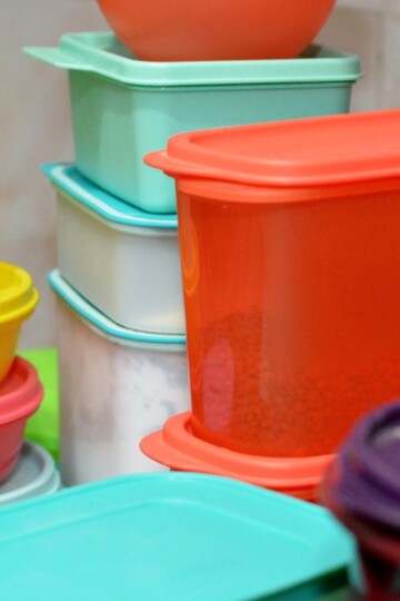collection of colorful Tupperware containers with lids on kitchen counter