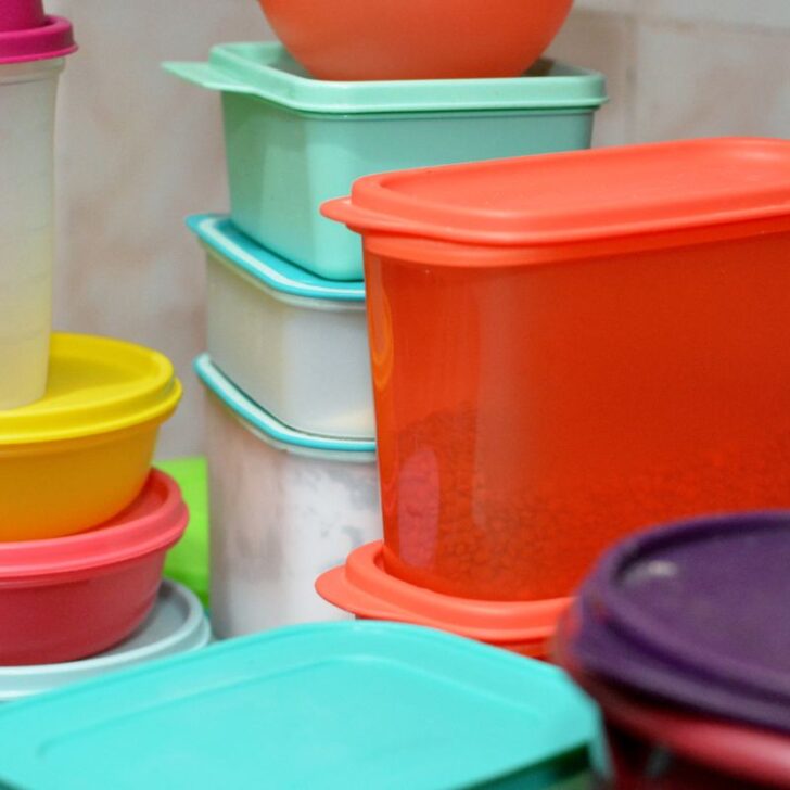 collection of colorful Tupperware containers with lids on kitchen counter