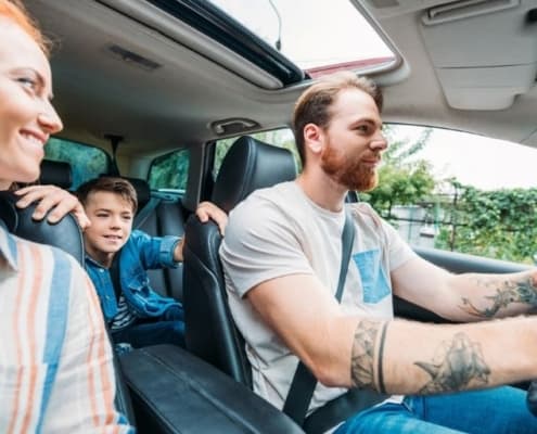 two parent and one child family in car, who downsized to one car family