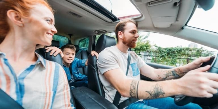 two parent and one child family in car, who downsized to one car family