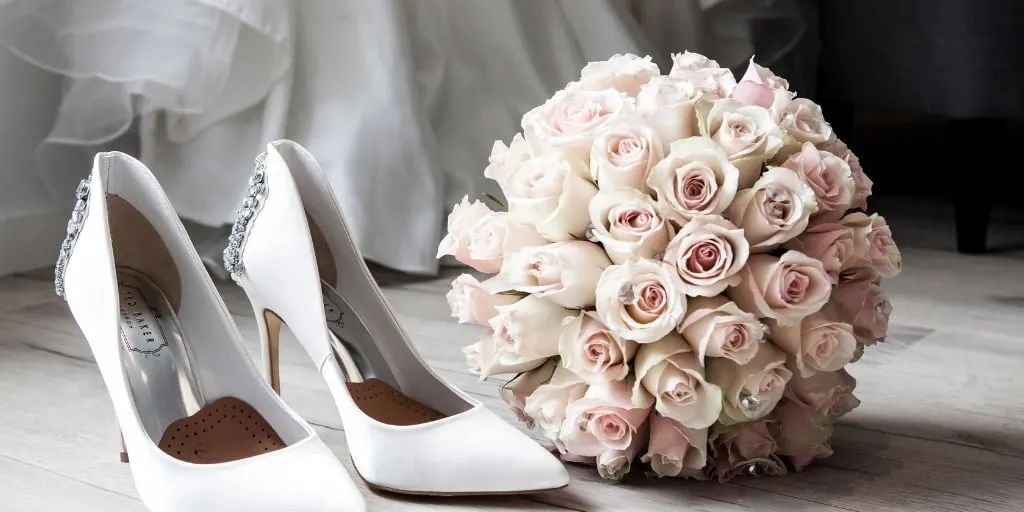 gorgeous white satin wedding heels and light pink rose bouquet