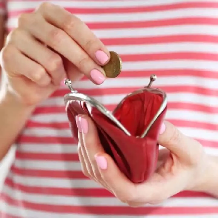 woman in red striped shirt putting coin into her red coin purse