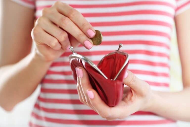 woman in red striped shirt putting coin into her red coin purse