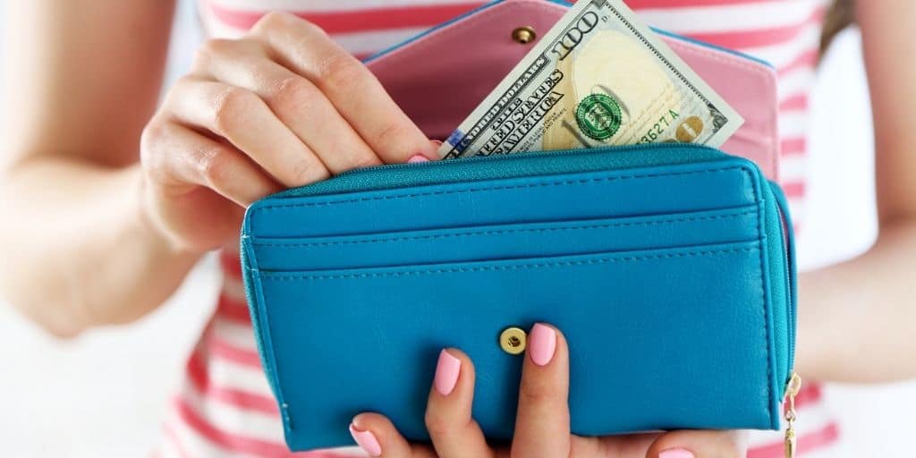 woman in red striped shirt with wallet of money, reading budgeting tips for beginners