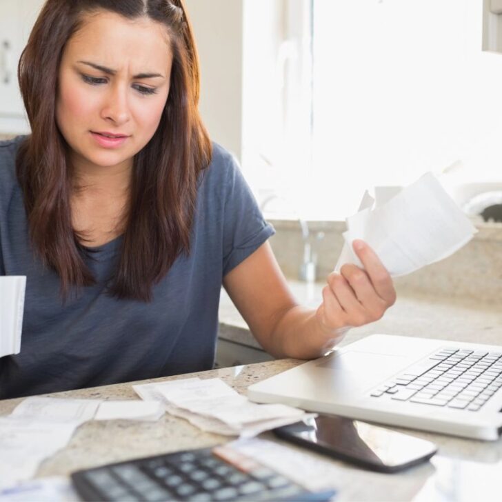 woman struggling with house bills at kitchen table