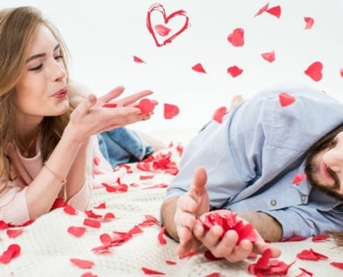 couple playing with rose petals as part of cheap valentine's day gift ideas