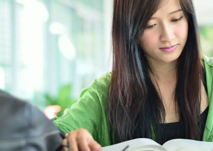 college student girl studying at desk, wondering how to save money as college student