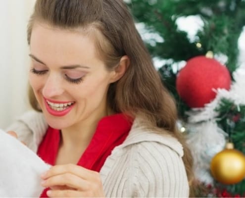 young woman looking into her stocking on Christmas