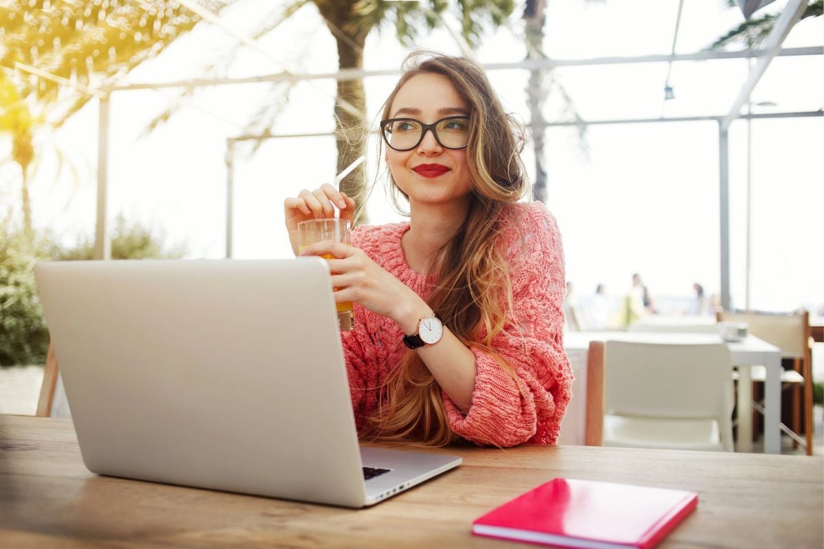 woman with red lipstick and iced coffee smiling