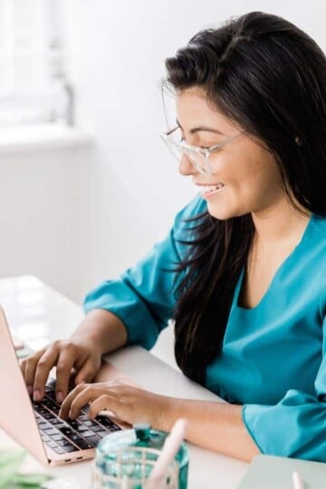 woman in teal taking money management free course on computer