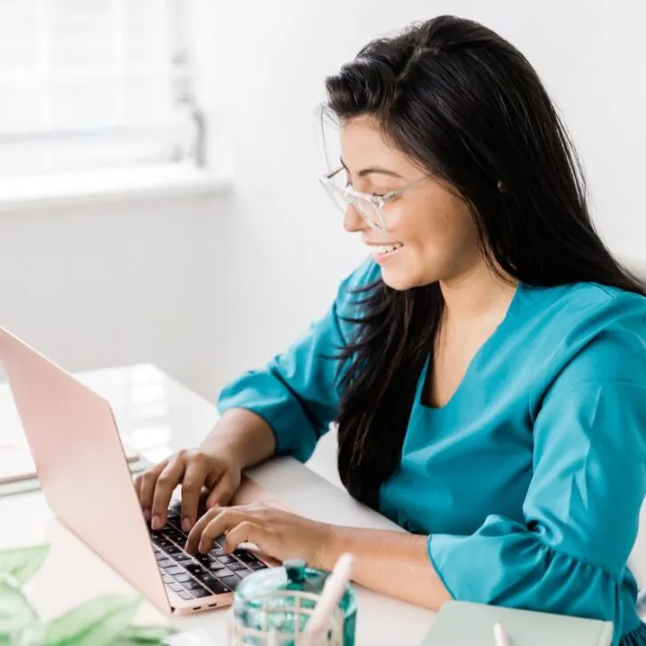 woman in teal taking money management free course on computer