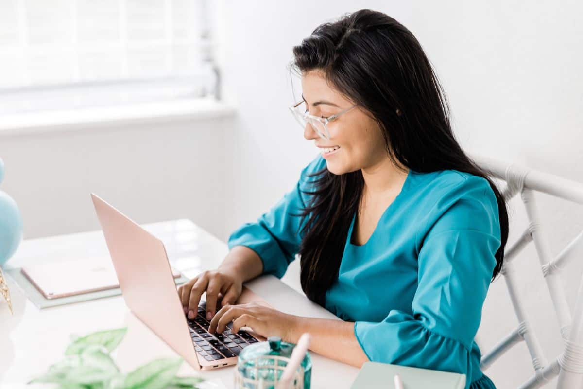 woman in teal taking money management free course on computer