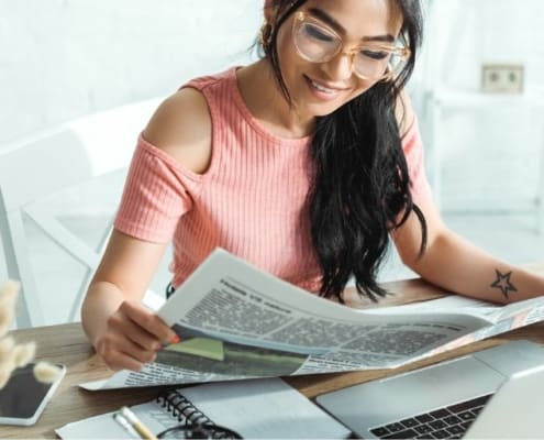 woman with glasses, reading newspaper about to get investment decision questions answered