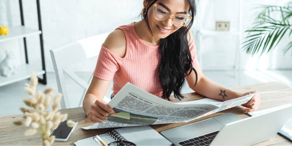 woman with glasses, reading newspaper about to get investment decision questions answered