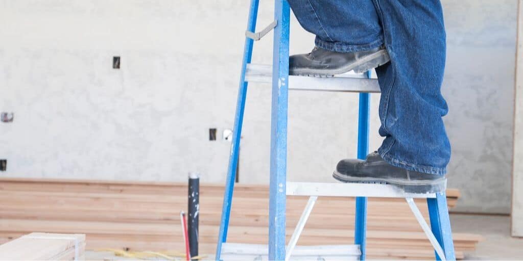 contractor on ladder, working on major home repair costs