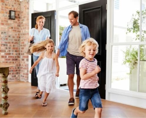 family of four running into their new home, going through the homeowner's insurance shopping process