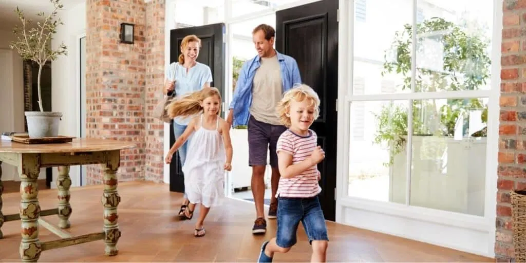 family of four running into their new home, going through the homeowner's insurance shopping process