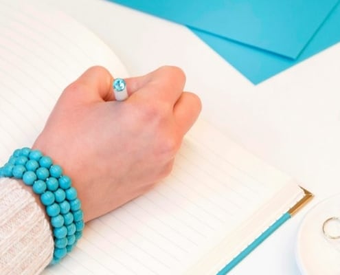 womans' hand using (bujo) bullet journal savings trackers